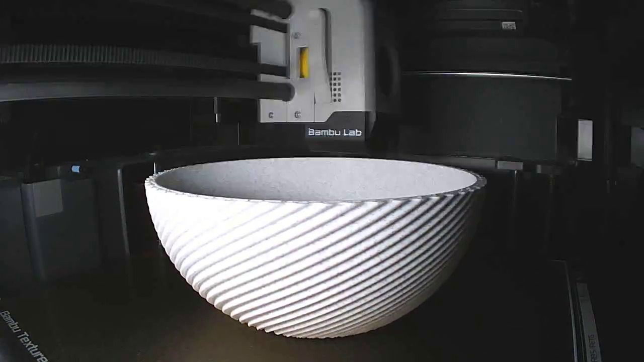 A ribbed white bowl on the bed of a Bambu Lab printer